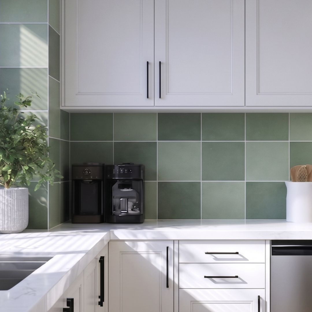 Modern kitchen with white cabinets, green tiled backsplash, and white countertops.